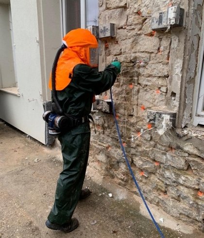 Un technicien procède au traitement fongique d'un mur